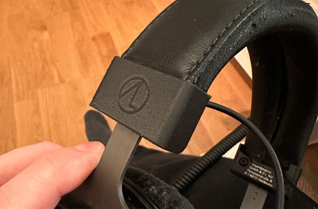 Three iterations of the 3D printed headphone part: original thin-walled version, thicker-walled version, and version with push-fit M3 inserts