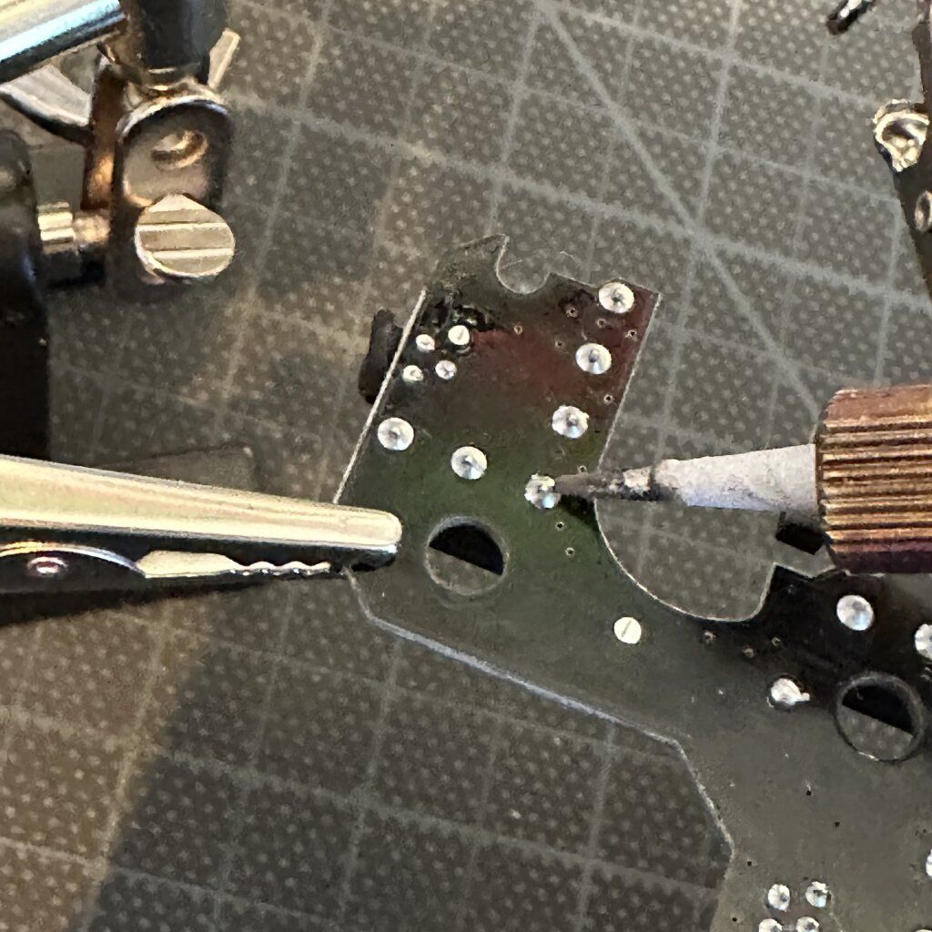 Soldering a replacement switch onto the mouse circuit board