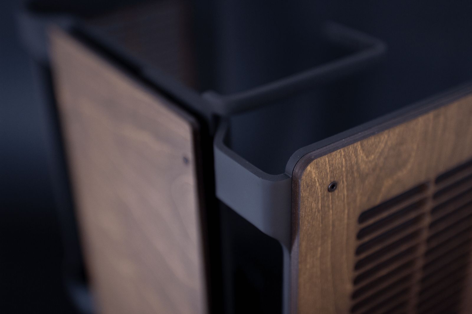 Close-up of the Tilia computer case showing the walnut wood and metal corner joint